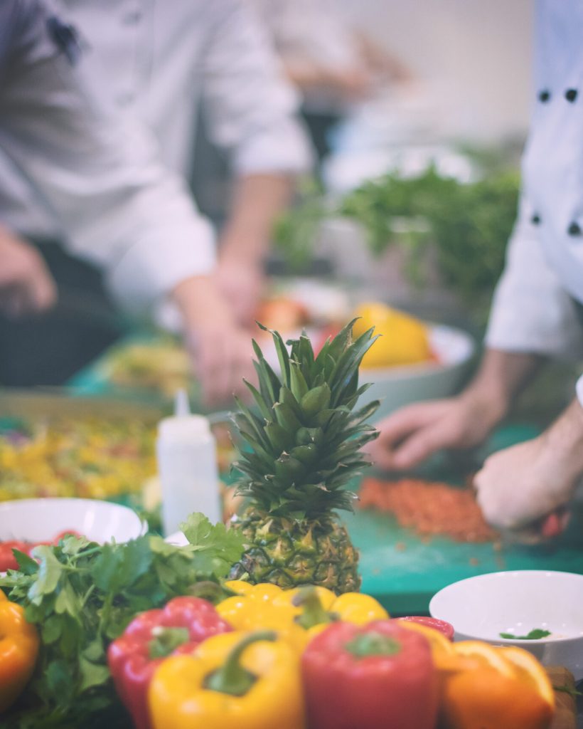 Professional team cooks and chefs preparing meals at busy hotel or restaurant  kitchen